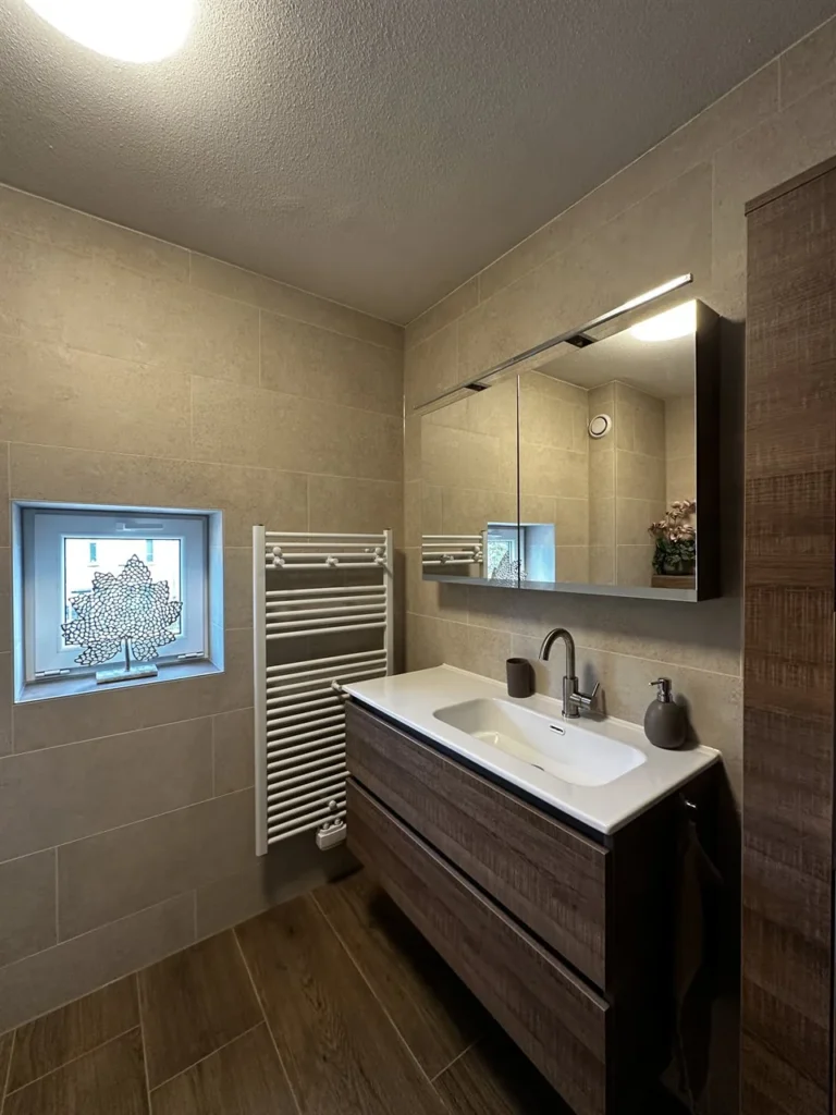 Badkamer met hangend badmeubel, radiator en houtlook vloertegels (Badkamer met houtlook tegels)