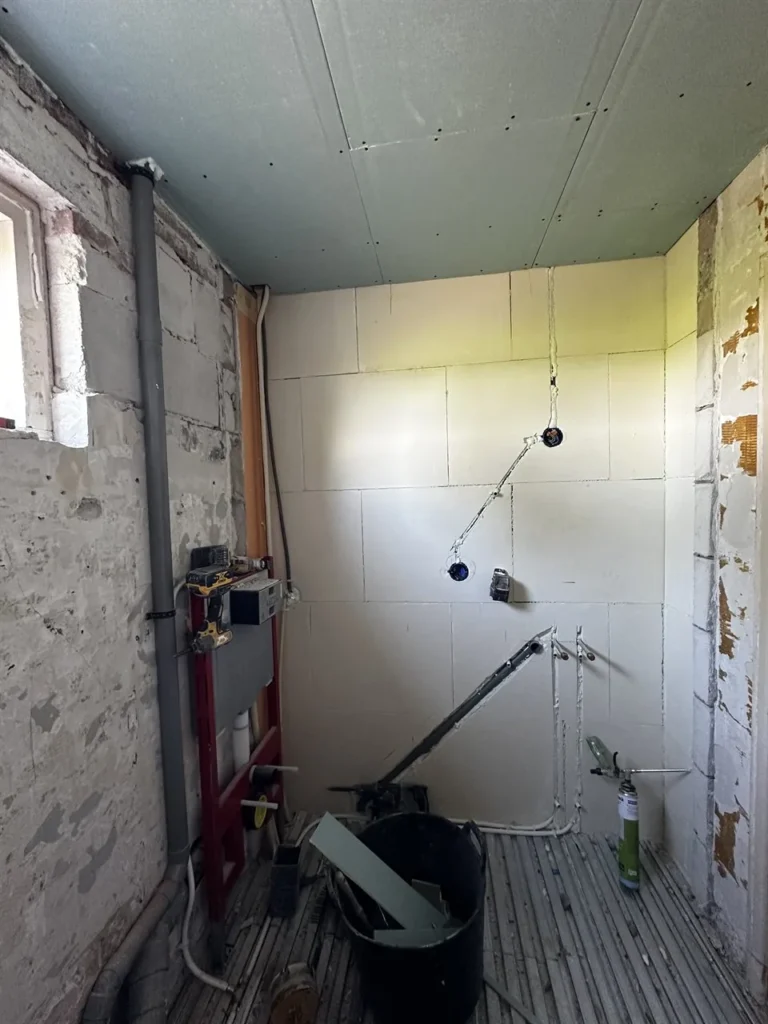 Badkamer voor de renovatie met kale wanden (Badkamer tijdens de verbouwing)