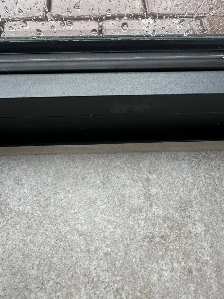 Detail grijze vloertegel bij de raamdorpel (Grijze grootformaat vloertegels)