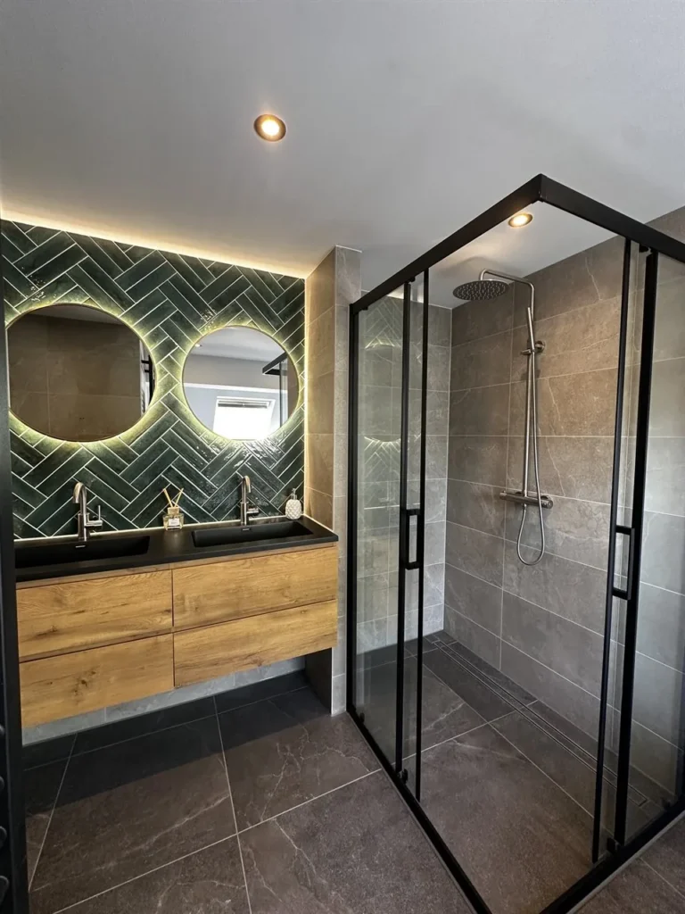 Douche met zwart kader naast dubbele wastafel (Luxe badkamer met groene tegels)
