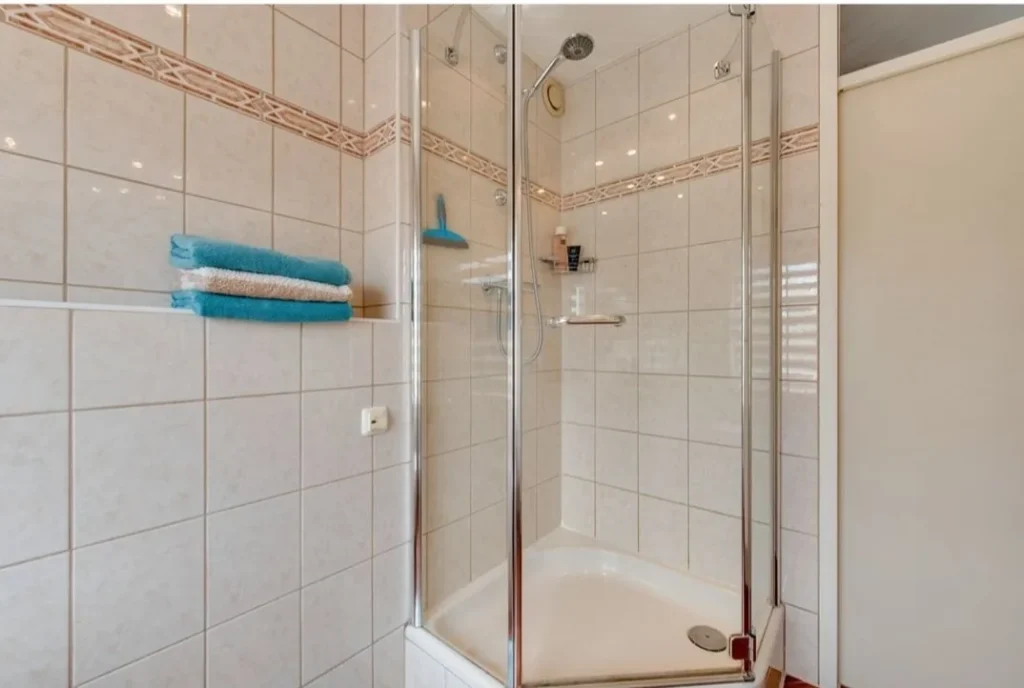 Douchehoek voor de renovatie met witte tegels (Badkamer renovatie met 3D-ontwerp)