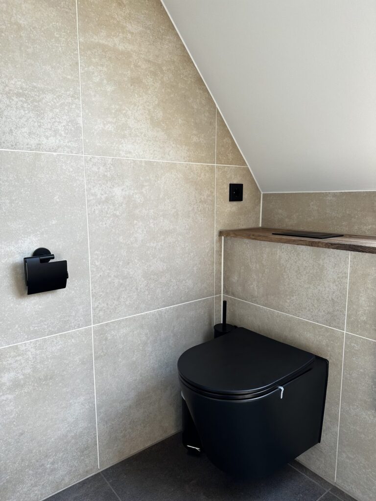 Zwart hangend toilet met beige tegels
