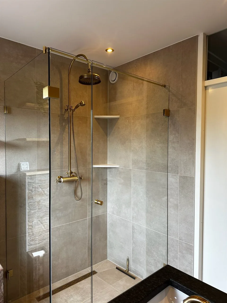 Inloopdouche met glazen wand en gouden douchekraan Inloopdouche met glazen wand en gouden douchekraan (Badkamer renovatie met 3D-ontwerp)