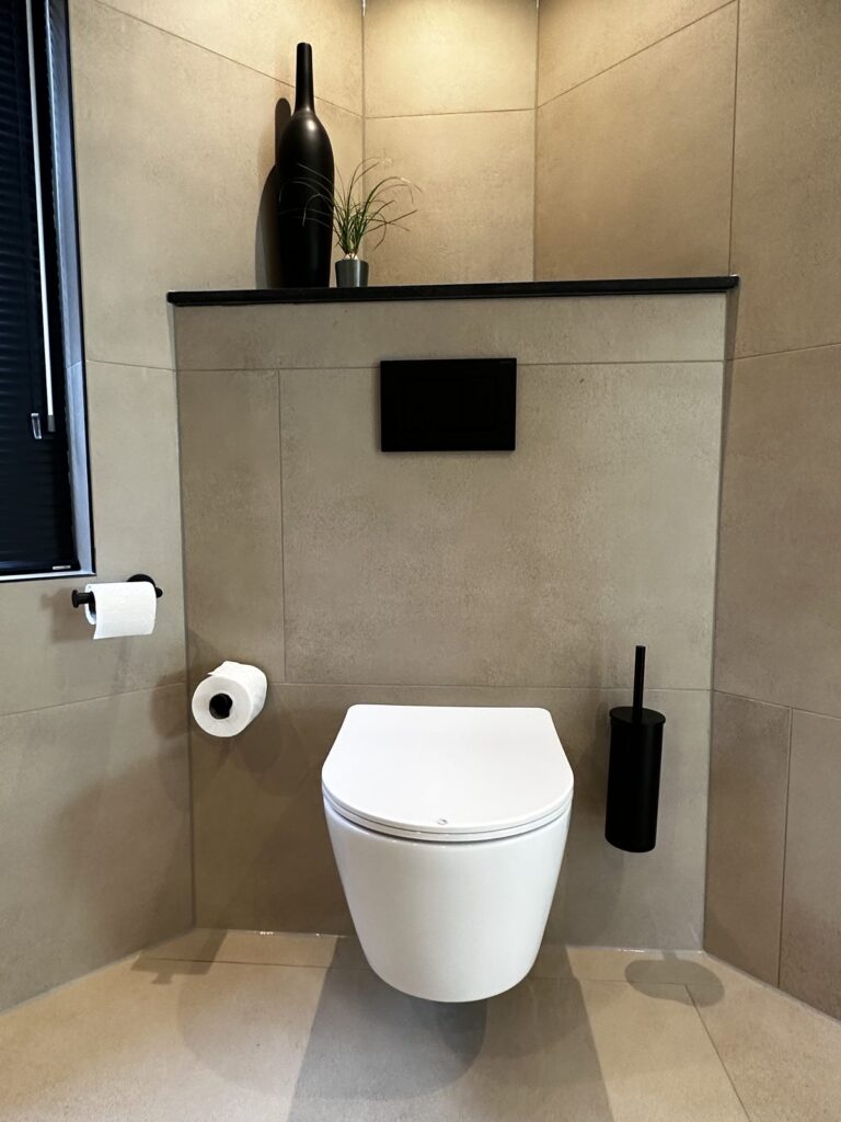 Hangend toilet met zwarte bedieningsplaat en beige tegels