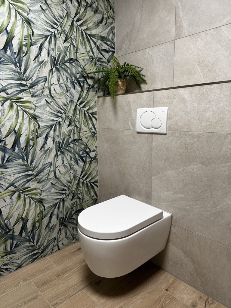 Wand met botanische bladtegels en hangend toilet in een moderne badkamer, gerealiseerd door MIJS Tegels & Sanitair