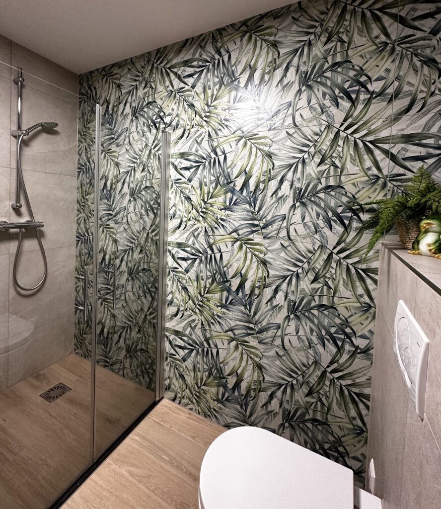 Inloopdouche met glazen wand en bladprint wandtegels in een moderne badkamer