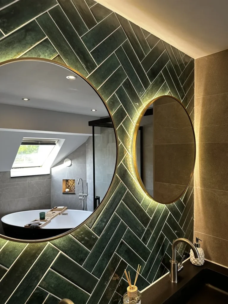 Ronde verlichte spiegels voor groene visgraattegels (Luxe badkamer met groene tegels)