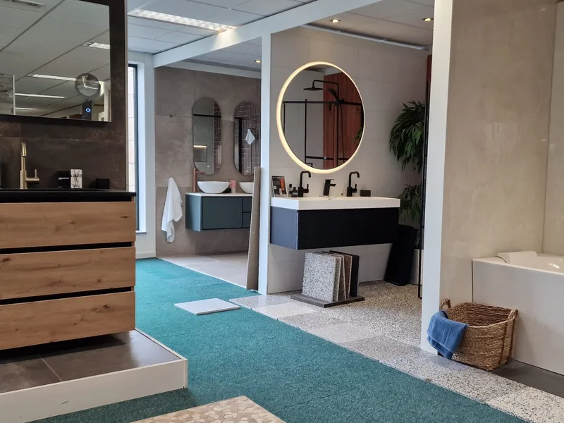 Showroom met badmeubel en bad Showroom van MIJS Tegels & Sanitair in Zwaag met een badmeubel, ronde spiegel en een bad