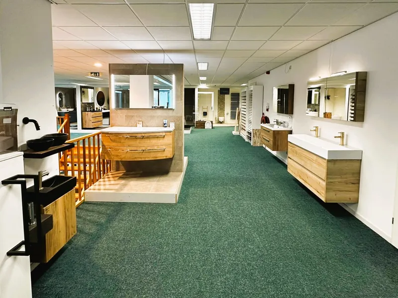 Showroomgang met badmeubels en wastafels in houtlook bij MIJS Tegels & Sanitair in Zwaag