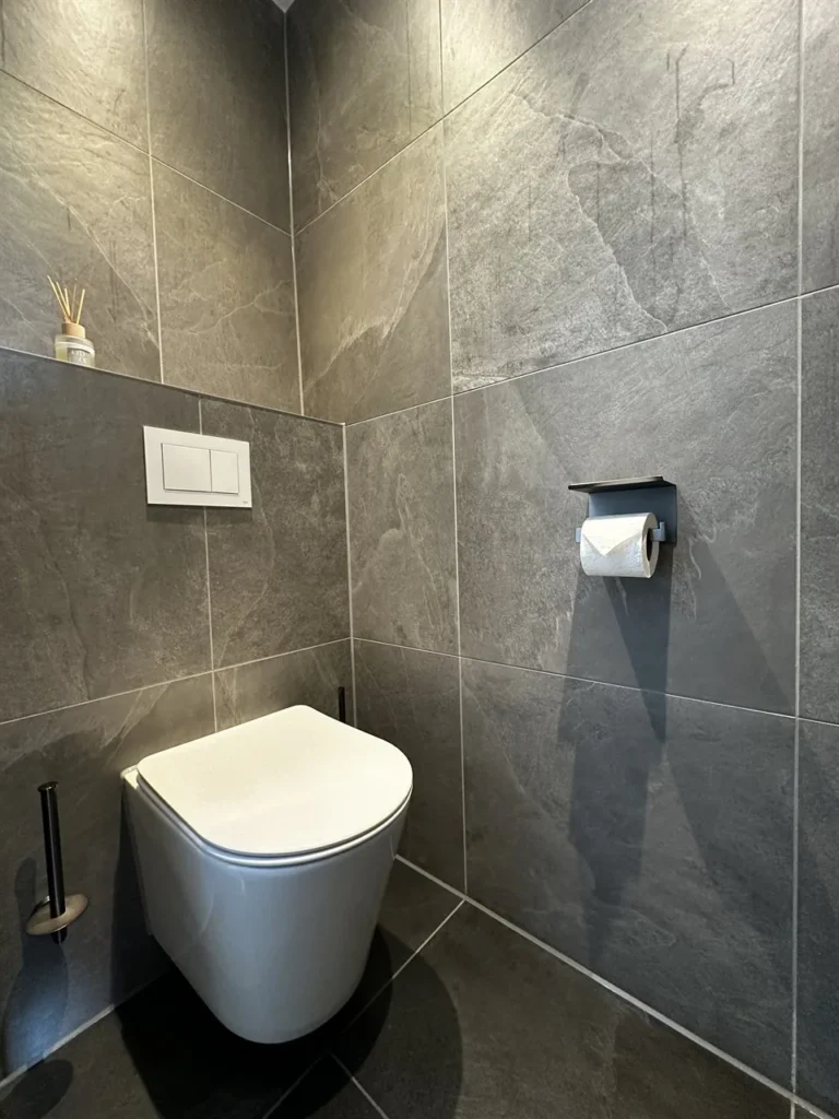 Toilet met leisteenlook tegels en zwarte accessoires (Badkamer met leisteenlook tegels)