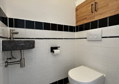 Toilet met retro witte tegels en zwarte rand