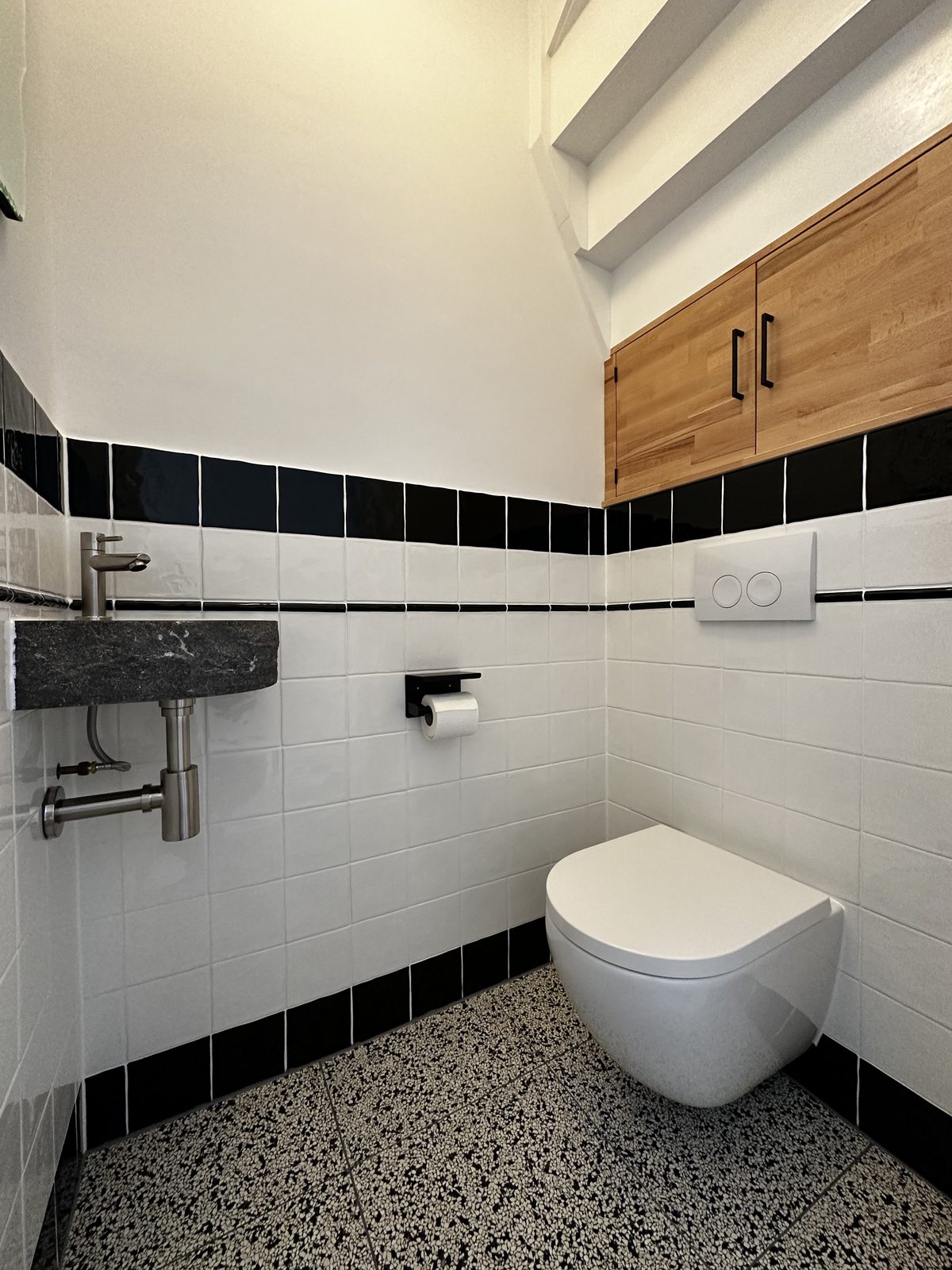 Toilet met witte tegels, zwarte rand en hangend toilet Toilet met witte tegels, zwarte rand en hangend toilet