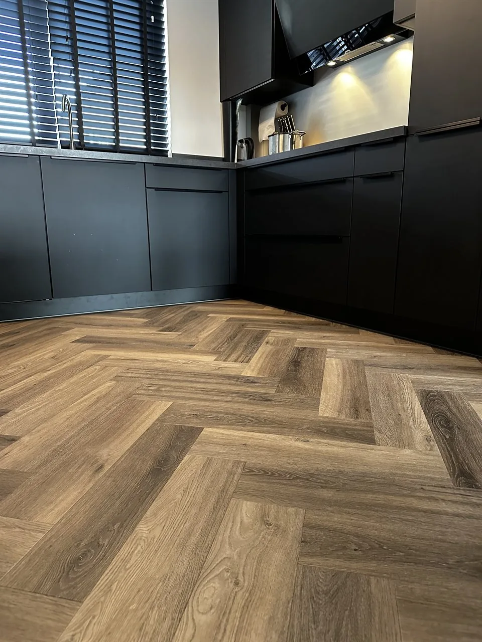 Visgraatvloer houtlook voor een zwarte keuken Visgraatvloer houtlook voor een zwarte keuken (Trap en visgraatvloer houtlook)