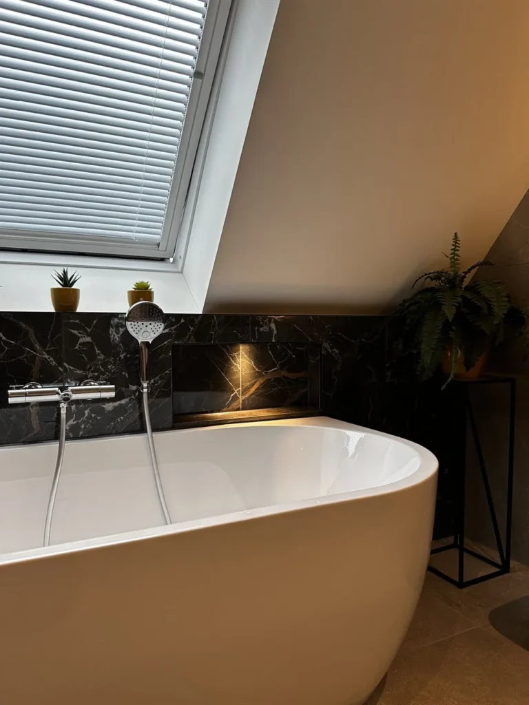 Vrijstaand bad met badkraan onder het dakraam (Badkamer met marmerlook tegels)