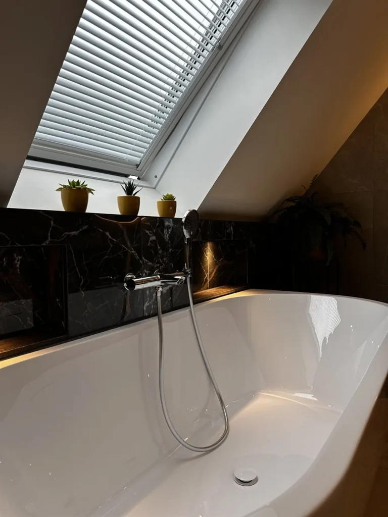 Vrijstaand bad met handdouche onder dakraam (Badkamer met marmerlook tegels)