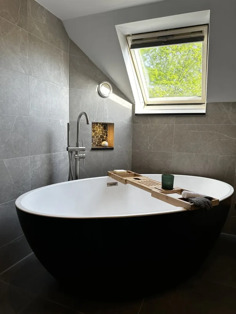 Vrijstaand zwart-wit bad onder het dakraam (Luxe badkamer met groene tegels)
