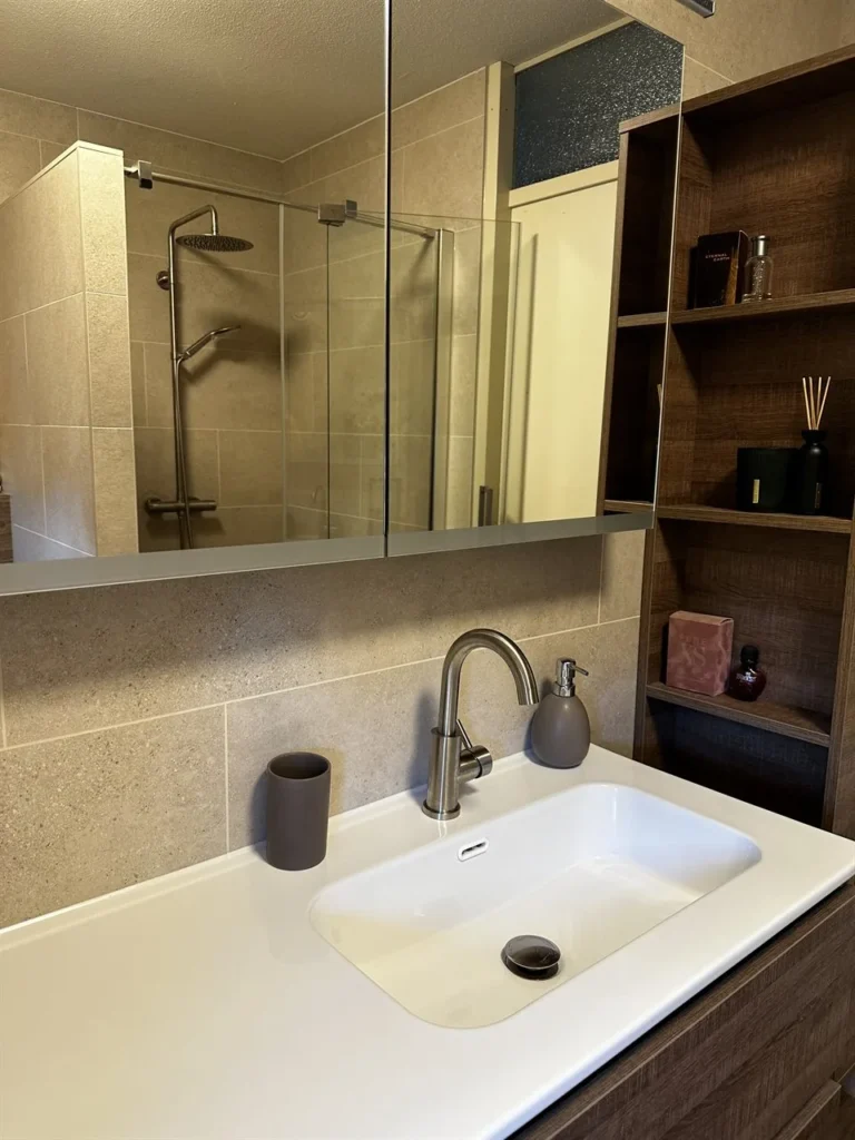 Wit wastafelblad met chromen kraan (Badkamer met houtlook tegels)