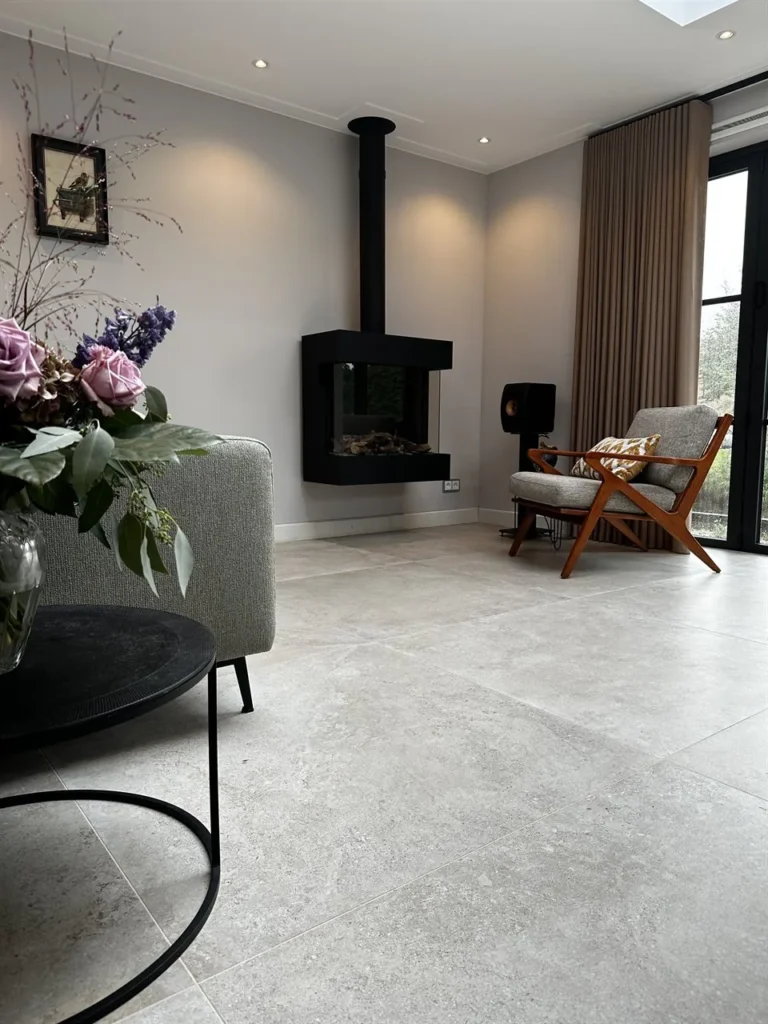 Woonkamer met bloemen en grijze vloertegels (Grijze grootformaat vloertegels)